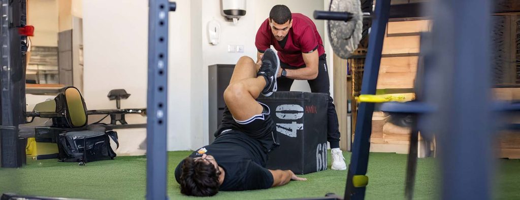 Physiolife physiotherapist assisting a leg rehabilitation exercise
