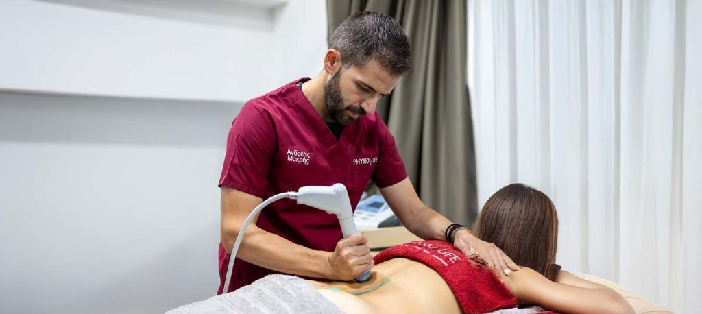 Physiolife therapist using a treatment device on a patient back